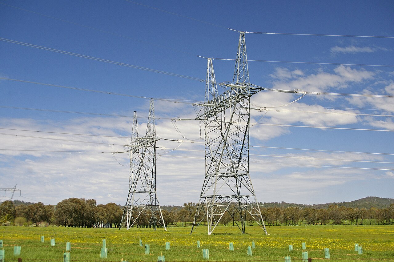 High-voltage transmission pylons — the physical grid that optimization software sits on