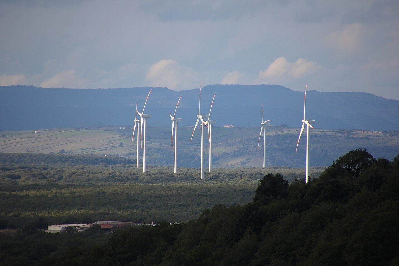 Wind turbines of the Campeda wind farm near Bonorva in Sardinia, Italy, seen from a hillside.