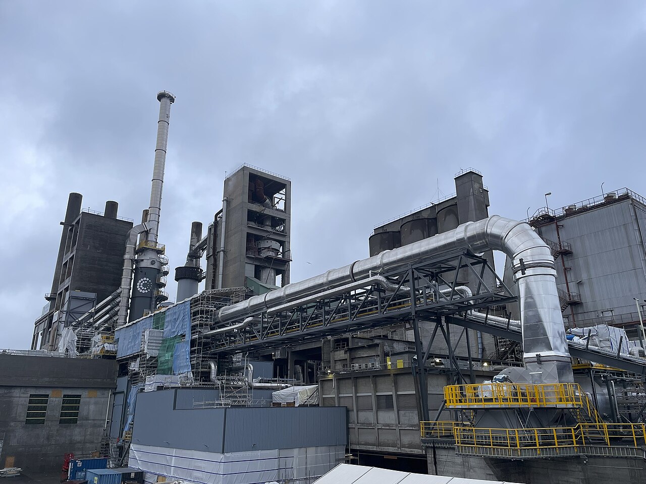Insulated duct and towers at Heidelberg Materials’ Brevik cement carbon-capture plant under a grey sky