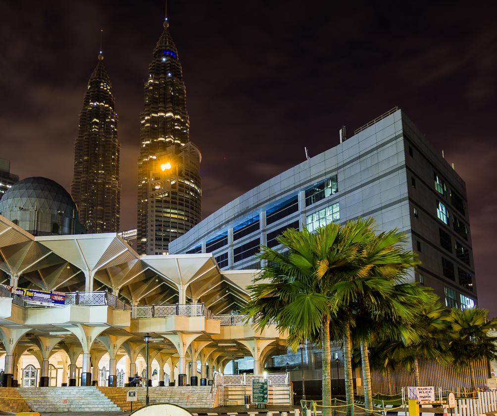 KLCC District Cooling building in Kuala Lumpur at night, with the Petronas Towers behind a white plant hall