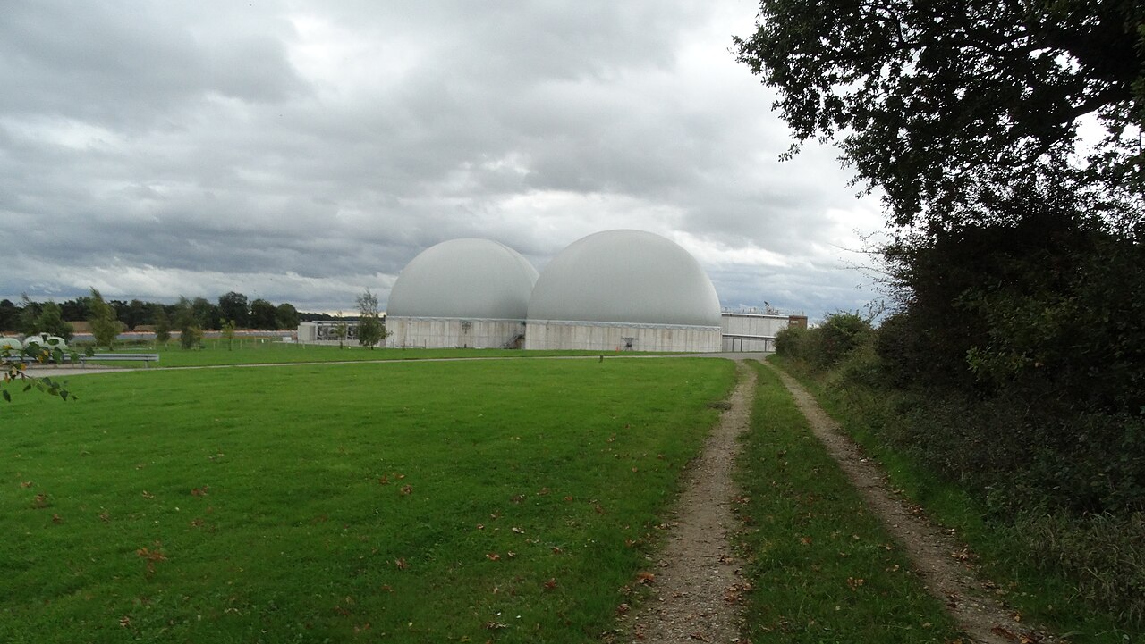 Two white biogas domes of the plant at Great Thorns Farm near Swaffham, seen across a grass field