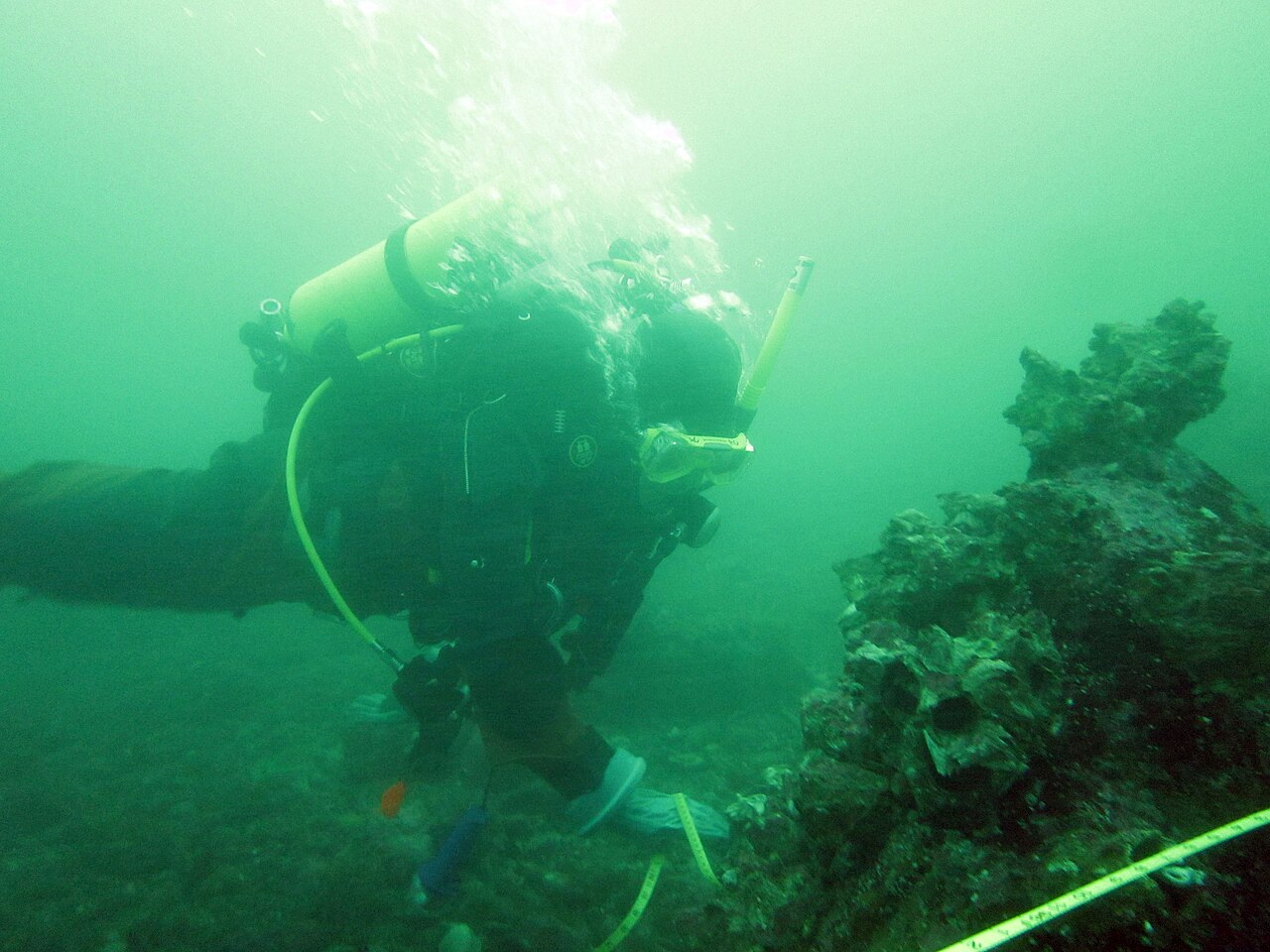 An EPA diver in Puget Sound lifting a mass of abandoned fishing net from the seabed