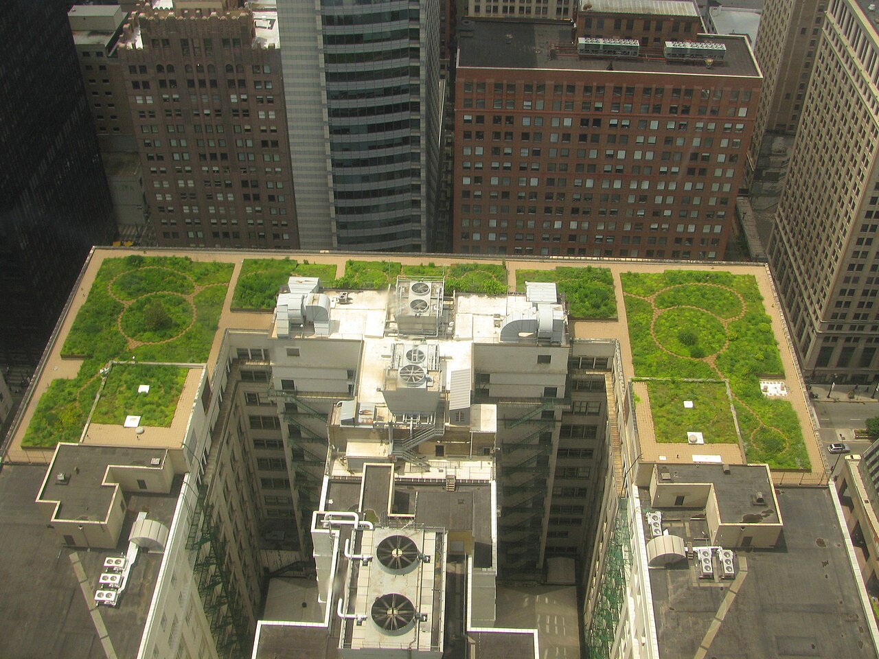 Aerial view of a planted roof with circular paths on a white downtown building among Chicago high-rises