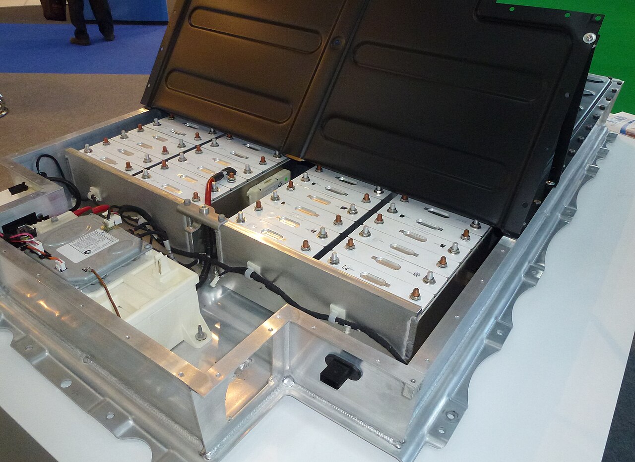 An open lithium-ion battery pack for an electric car on show at a trade fair in Munich, with its modules and control electronics exposed.