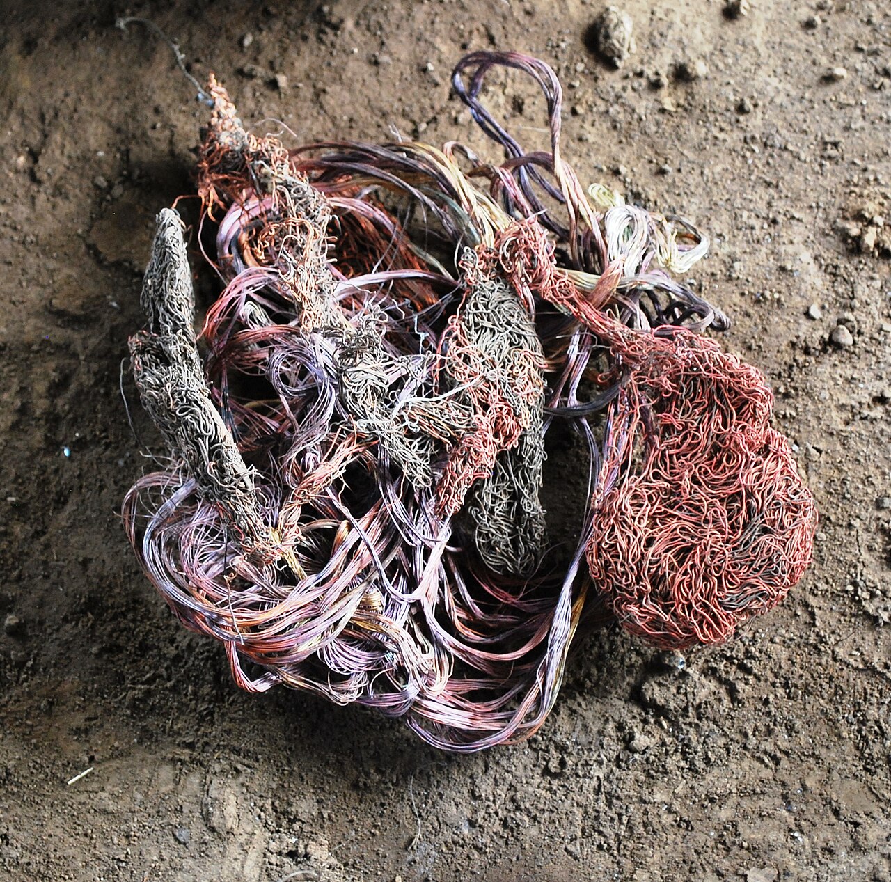 Bundle of stripped copper wire scrap on bare ground in Santa Clara del Cobre
